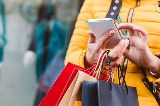 Women holding shopping bags and using her mobile phone