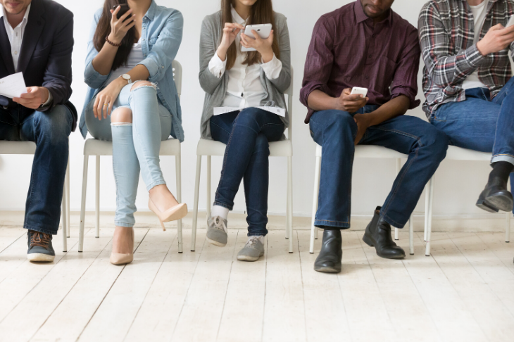 Gente sentada leyendo SMS en su móvil