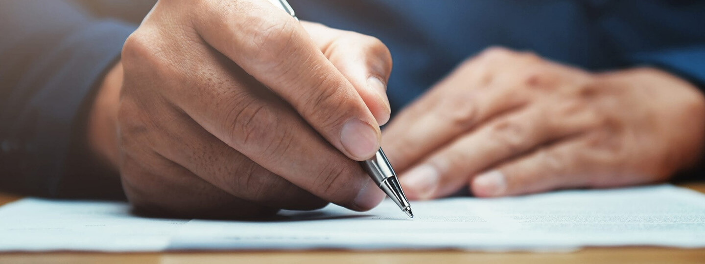 Mano escribiendo sobre papel con un boli
