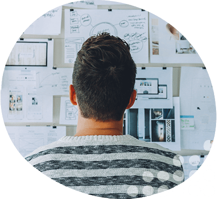 Photo of person looking at board with various ideas and images for market research purposes